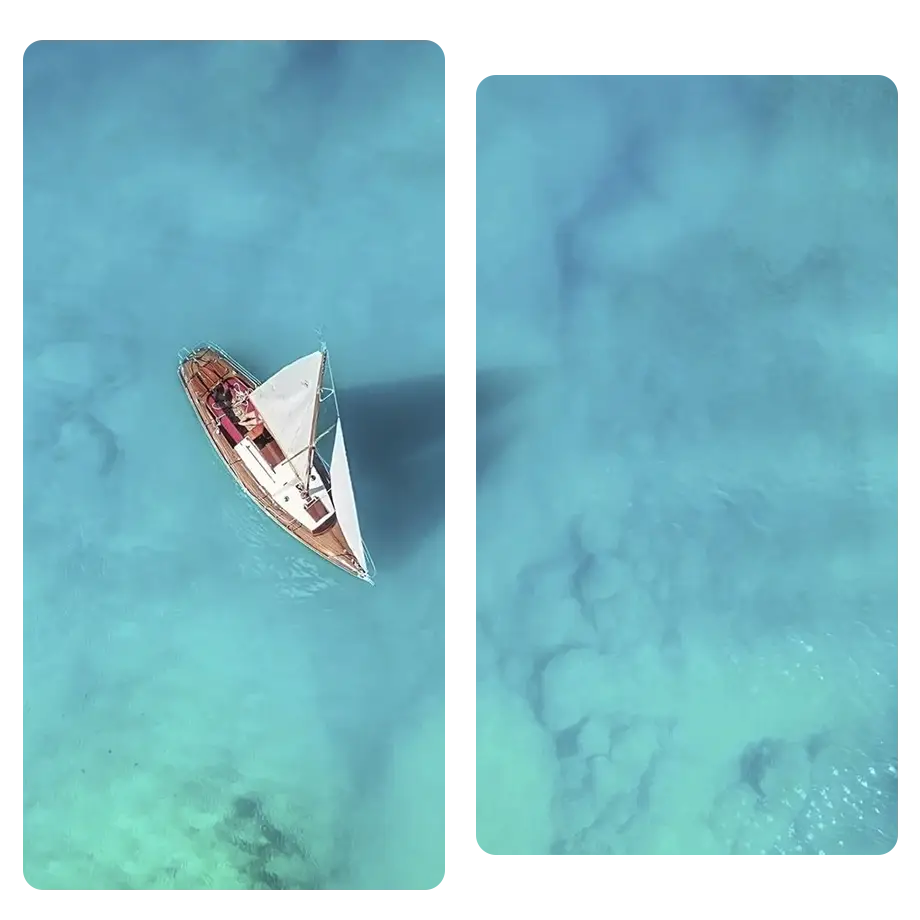 Birds eye view of a yacht sailing in clear waters